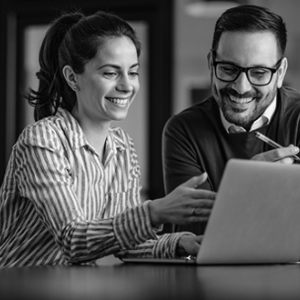 Man and woman looking at laptop while smiling
