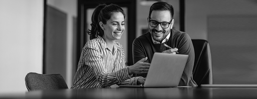 Man and woman looking at laptop while smiling