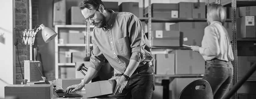 man holding package at desk while working