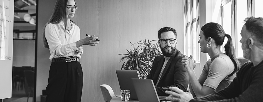 Employees discussing cybersecurity sitting at table with laptops