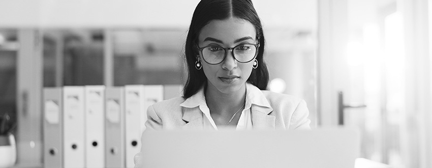 woman typing on laptop avoiding cybersecurity risks with MFT