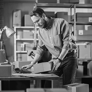 man holding package and working at desk