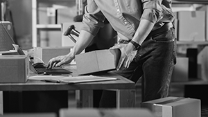 man holding package and working at desk