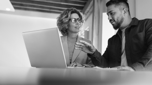 two coworkers speaking at their laptop