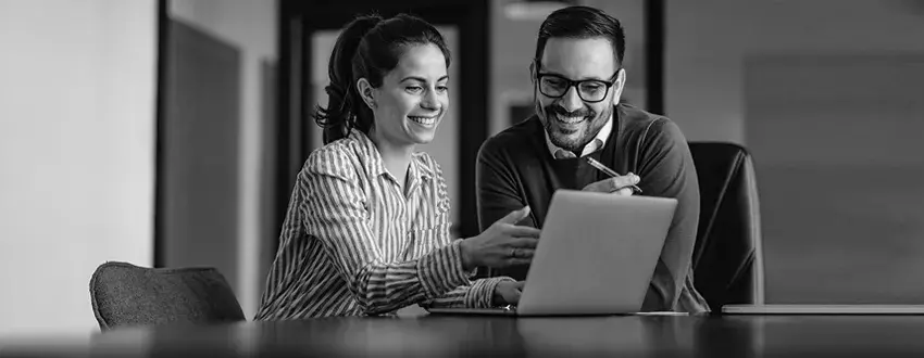 Man and woman looking at laptop while smiling