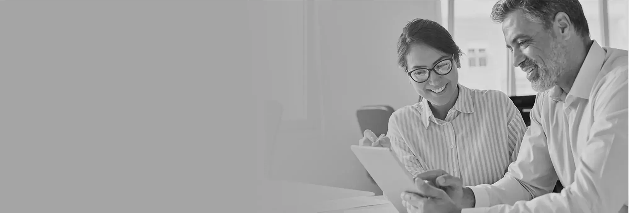 Man and woman reviewing information on a tablet device